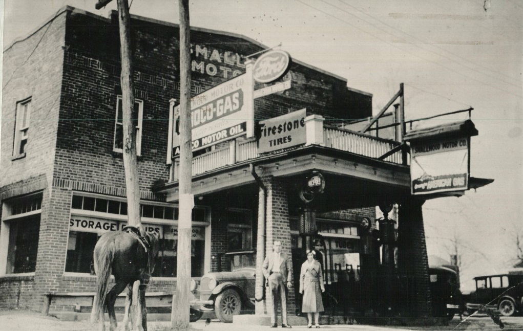 Two people and a horse stand in front an a store