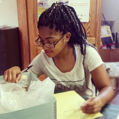 Tamysinae Brown looking through a box of artifacts in Westmoreland County Museum